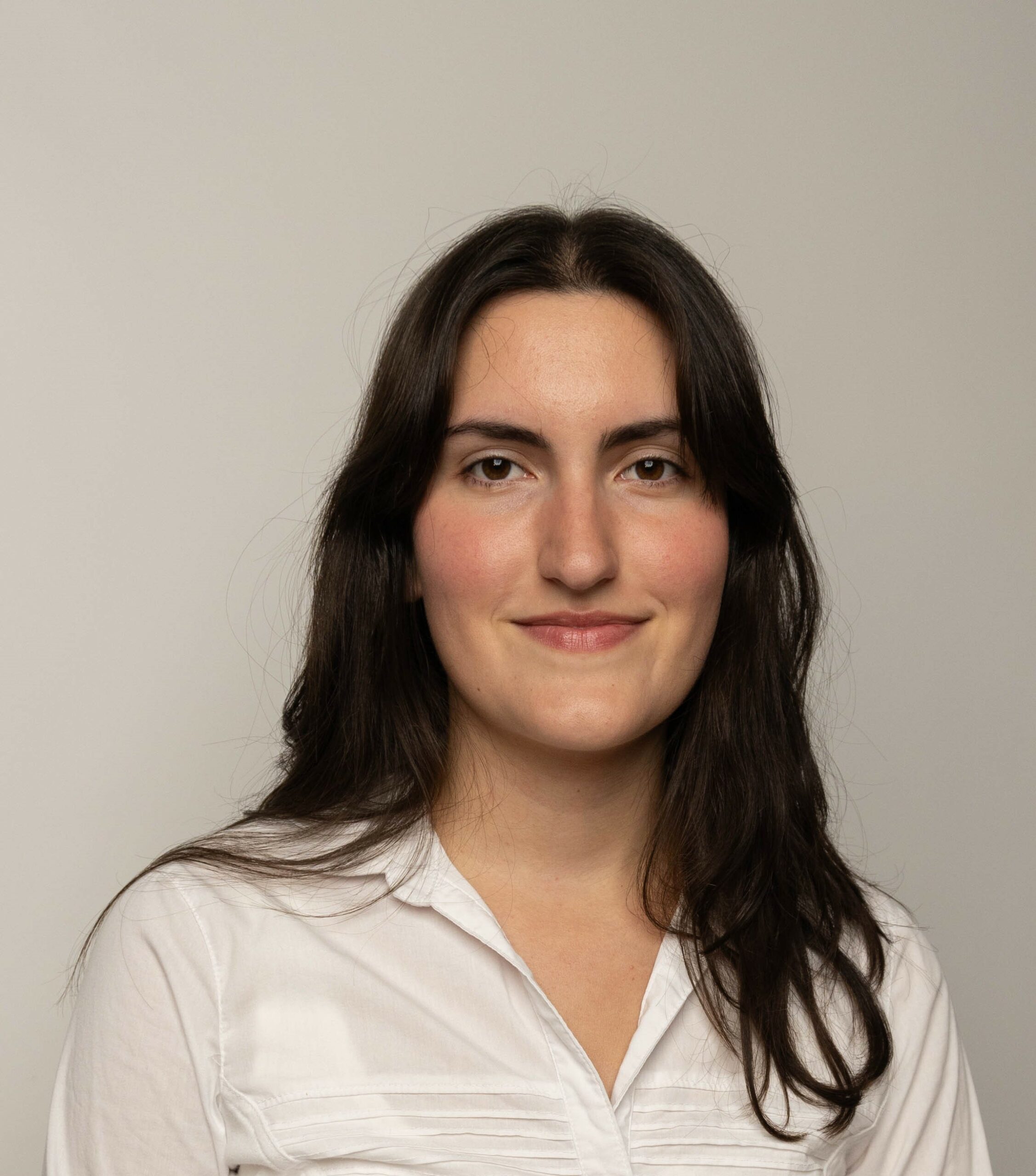 Headshot of Kristina Minic, looking straight ahead in a white collared shirt.