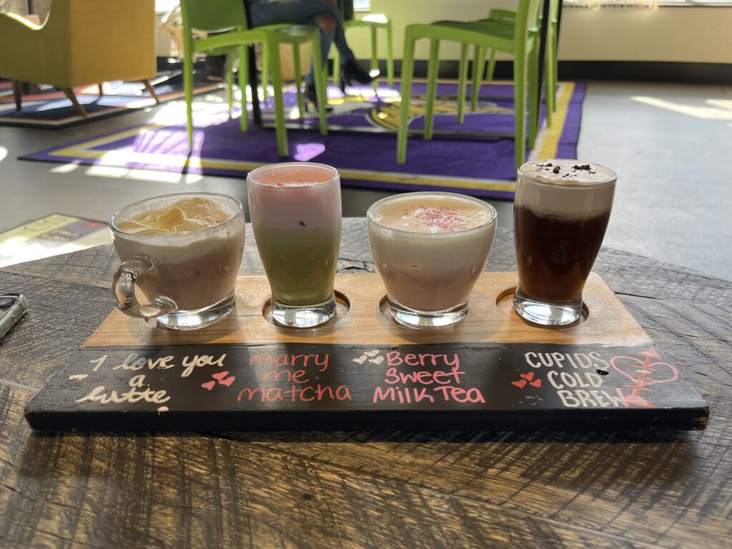 Four different types of coffee sat on a flight board, each with descriptions.