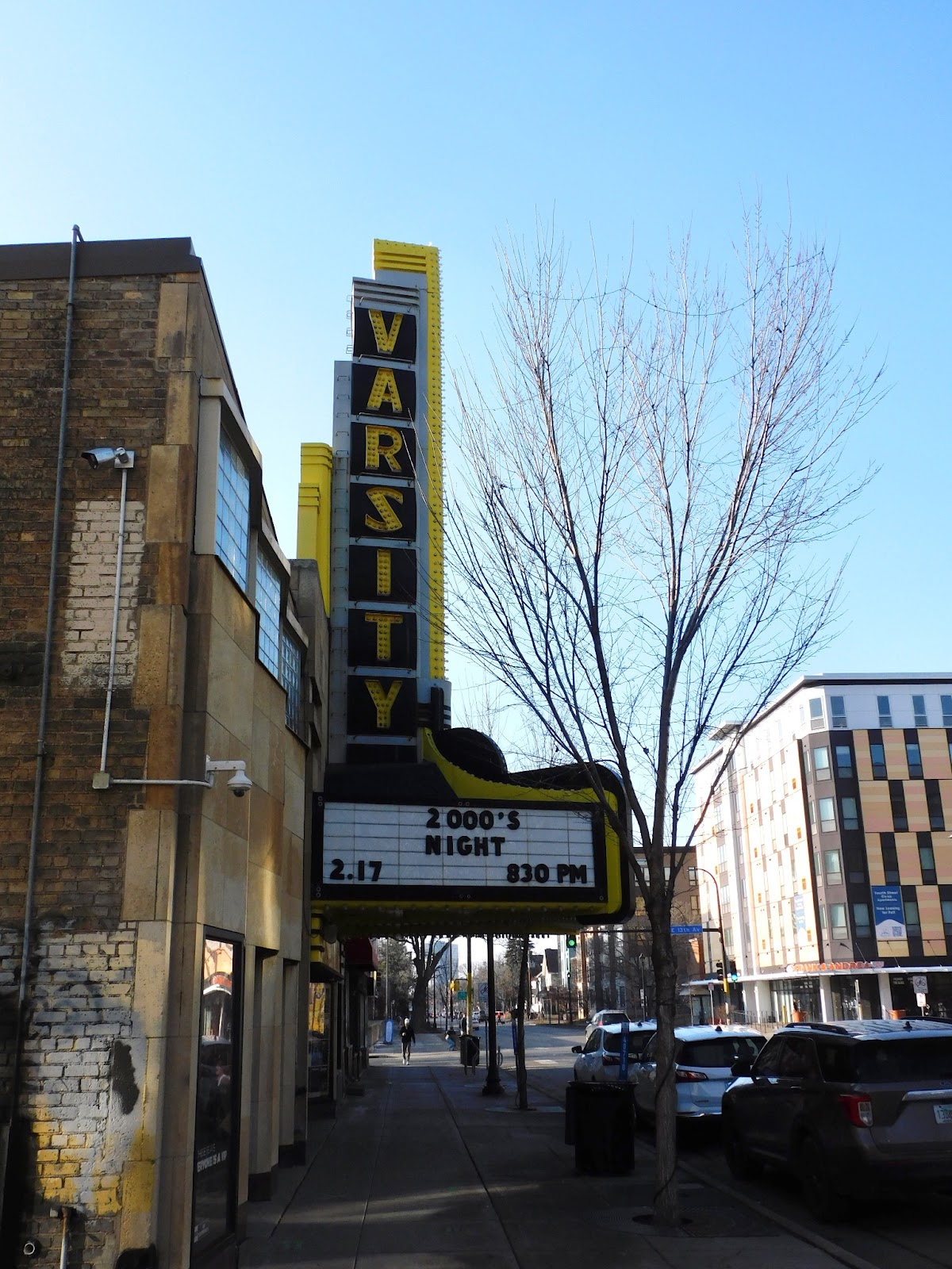 An image of a brick building with a large marquee sign that reads “VARSITY".